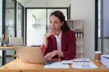 İş yerinde dizüstü bilgisayar kullanan bir kadın. İş kadını dizüstü bilgisayarın ekonomi raporunu hazırlıyor.