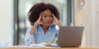 Düşünceli, kafası karışmış genç afro-amerikan iş kadını dizüstü bilgisayara bakıyor. Haber, haber ya da e-posta okurken stres. Çevrimiçi problem, finansal hata, sorun yaratma.