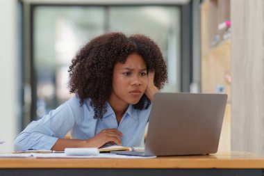 Düşünceli, kafası karışmış genç afro-amerikan iş kadını dizüstü bilgisayara bakıyor. Haber, haber ya da e-posta okurken stres. Çevrimiçi problem, finansal hata, sorun yaratma.