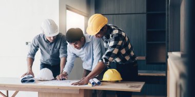 Profesyonel mimar tasarımcı yapı mühendisi takım arkadaşları bina tasarım projesini tartışıyor.