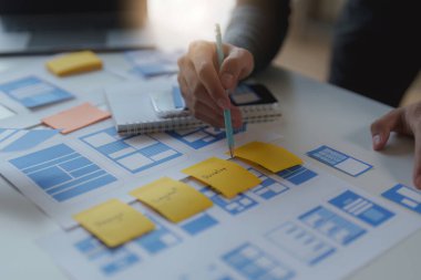 Mobil uygulamaların içeriğini oluşturmak için çalışan UX UI ya da tasarımcı grubu. Yaratıcı dijital geliştirme ajansı kavramı.