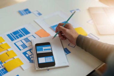 Mobil uygulamaların içeriğini oluşturmak için çalışan UX UI ya da tasarımcı grubu. Yaratıcı dijital geliştirme ajansı kavramı.