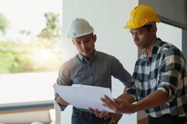 Profesyonel mimar tasarımcı yapı mühendisi takım arkadaşları bina tasarım projesini tartışıyor.