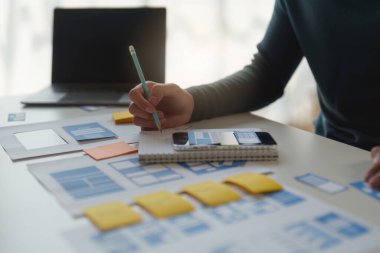 Mobil uygulamaların içeriğini oluşturmak için çalışan UX UI ya da tasarımcı grubu. Yaratıcı dijital geliştirme ajansı kavramı.