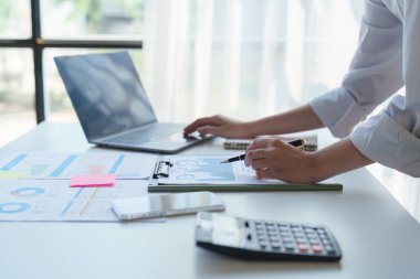 İç işlerinde çalışan Asyalı iş adamları mali raporları analiz ediyorlar. Muhasebe ve Finans kavramı.