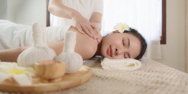 Genç bir kadın spa salonunda masaj yapıyor. Bir masör tarafından masaj yapılan bir kadın. Spa ve tıp konsepti.