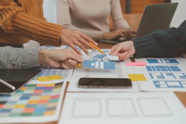 Genç Asyalı yaratıcı ofiste yeni bir iş kuruyor. Modern bir şirket kurma takımı. Meslektaşları ui, ux küçük işletme.