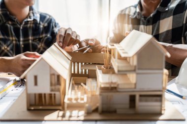 Mimarlık ekibi ofiste planlar üzerinde çalışırken bir şeyler çiziyor. Mimarlık ve Mühendislik kavramı.