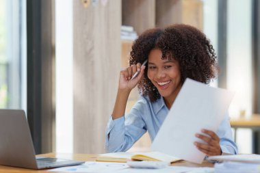Dizüstü bilgisayarda çalışan siyahi iş kadını mutlu bir şekilde kazanıyor. Heyecanlı kadın zaferi işten iyi haberler alıyor..