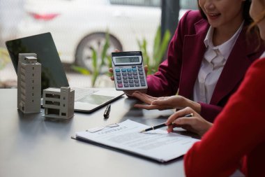 Emlakçı kontratı imzalamadan önce müşteriye sigorta ve anlaşma sözleşmesini açıklar. Emlak sigortası ve güvenlik kavramı.