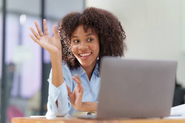 Laptop görüntülü konferans görüşmesi yapan çekici siyahi iş kadını, iş arkadaşları. Ekiple iletişim..