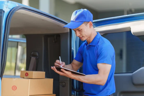 Asian courier with parcel and delivery logistic concept. Delivery man using digital tablet.