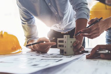 Mimarlık planının planlarıyla çalışan mimar takımı, bir inşaat projesi çizen mühendis, yeşil enerji konsepti.