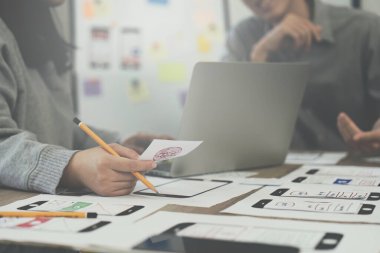 Genç Asyalı yaratıcı ofiste yeni bir iş kuruyor. Modern bir şirket kurma takımı. Meslektaşları ui, ux küçük işletme.