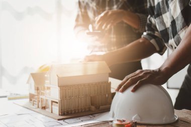 Mimarlık ekibi ofiste planlar üzerinde çalışırken bir şeyler çiziyor. Mimarlık ve Mühendislik kavramı.