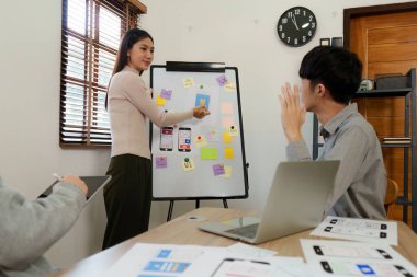 Genç Asyalı yaratıcı ofiste yeni bir iş kuruyor. Modern bir şirket kurma takımı. Meslektaşları ui, ux küçük işletme.