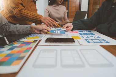 Genç Asyalı yaratıcı ofiste yeni bir iş kuruyor. Modern bir şirket kurma takımı. Meslektaşları ui, ux küçük işletme.