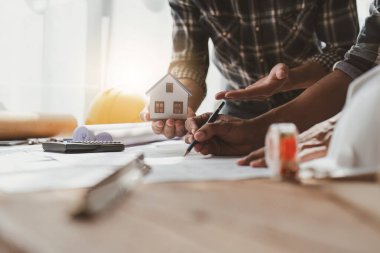 Mimarlık ekibi ofiste planlar üzerinde çalışırken bir şeyler çiziyor. Mimarlık ve Mühendislik kavramı.