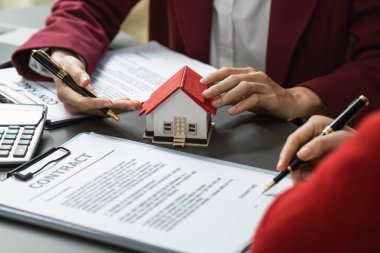 Emlakçı kontratı imzalamadan önce müşteriye sigorta ve anlaşma sözleşmesini açıklar. Emlak sigortası ve güvenlik kavramı.