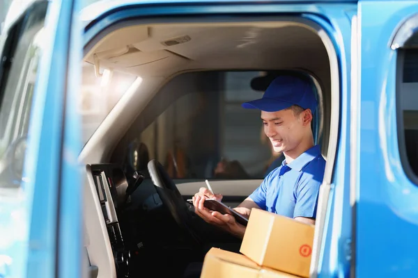 Asian courier with parcel and delivery logistic concept. Delivery man using digital tablet.