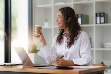 Merkez büroda çalışan bir iş kadını ve mali rapor belgelerini analiz ediyor. Muhasebe ve Finans kavramı.