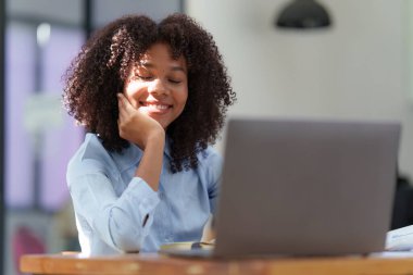 Laptop görüntülü konferans görüşmesi yapan çekici siyahi iş kadını, iş arkadaşları. Ekiple iletişim..