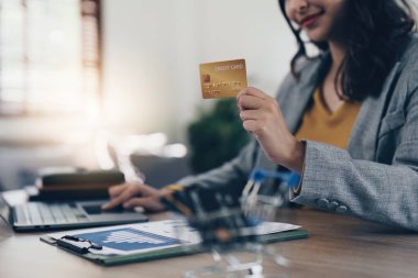 Genç Asyalı kadın faturaları kontrol ediyor, banka hesapları, vergiler ve ev harcamaları hesaplanıyor.