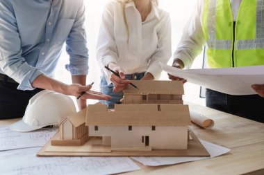 Mimarlık planının planlarıyla çalışan mimar takımı, bir inşaat projesi çizen mühendis, yeşil enerji konsepti.