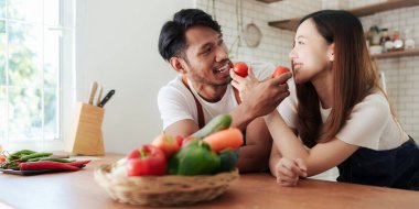 Portrait of young asian couple making salad together at home. cooking food and Lifestyle moment and healthy