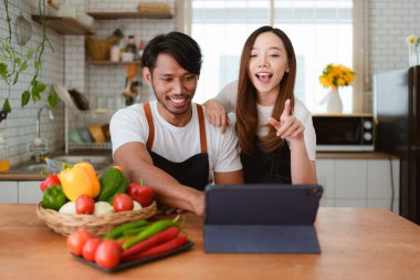 Portrait of young asian couple making salad together at home. cooking food and Lifestyle moment and healthy.