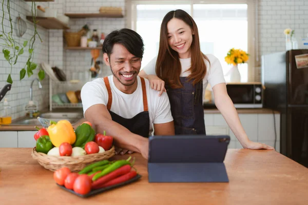 Portrait of young asian couple making salad together at home. cooking food and Lifestyle moment and healthy.