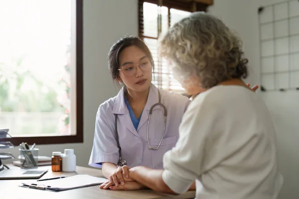Doctor talking with elderly asian woman. Female primary care physician having conversation with older woman. Elderly Healthcare.