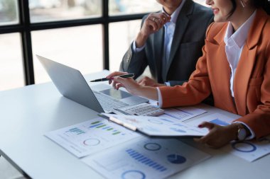 Beautiful business woman consultant talking with asian business person at meeting room with new financial market. Accounting concept.