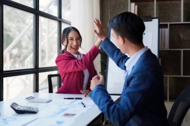 Asian business team happy to be successful partnership teamwork celebrating achievement and success concept. Beautiful business team celebrate with laptop.