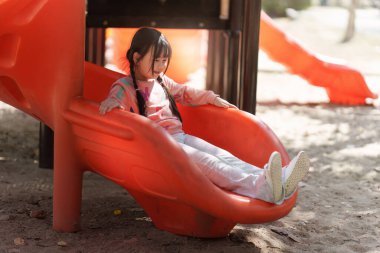 Happy Asian children playing at playground at outdoor park.
