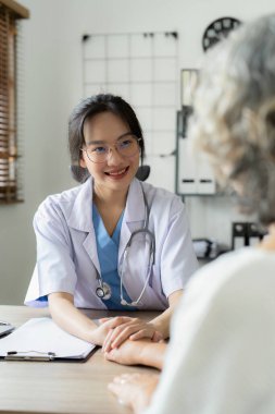 Doctor talking with elderly asian woman. Female primary care physician having conversation with older woman. Elderly Healthcare.