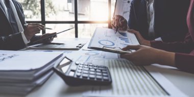 Close up of Diverse colleagues gather brainstorm discuss financial statistics at office meeting. finance, teamwork, Big data Graphs Charts concept.