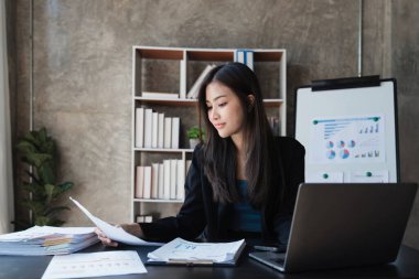 Beautiful Business woman working at home office and analyze financial report document. Accounting and Finance concept.