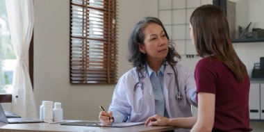 Kıdemli Doktor ve hastası. Doktor, hastanedeki kadın hastaya tavsiye veriyor..