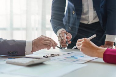 Close up of Diverse colleagues gather brainstorm discuss financial statistics at office meeting. finance, teamwork, Big data Graphs Charts concept.
