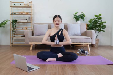 Healthy asian woman practicing relaxation yoga at home. Spending time and playing at home concept.