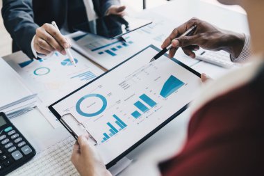 Close up of Diverse colleagues gather brainstorm discuss financial statistics at office meeting. finance, teamwork, Big data Graphs Charts concept.