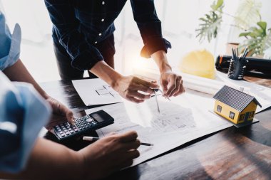 Architecture or Civil engineer team analyze with construction blueprint. plan, engineer sketching a construction project, green energy concept.