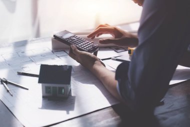 Architecture or Civil engineer analyze with construction blueprint. plan, engineer sketching a construction project, green energy concept.