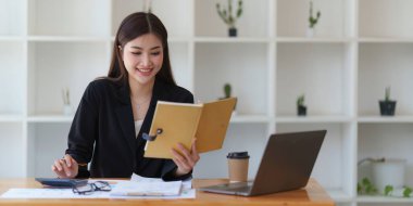 İç işlerinde çalışan Asyalı İş kadını mali raporları analiz ediyor. Muhasebe ve Finans kavramı.