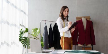 Beautiful young professional stylist working at design studio interior. fashion designer concept.