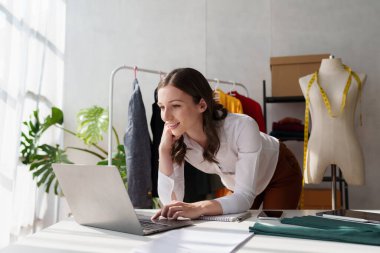 Beautiful young professional stylist working at design studio interior. fashion designer concept.