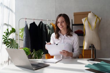 Beautiful young professional stylist working at design studio interior. fashion designer concept.