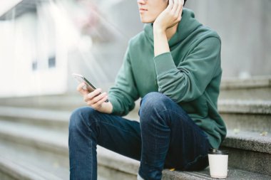 Genç Asyalı öğrenci telefon kullanarak zaferi kutluyor..