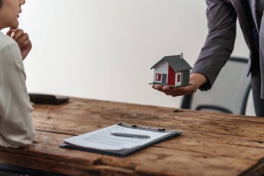 Close up Business man or Real Estate agent explain signing agreement for buying house. Bank manager and real estate concept.